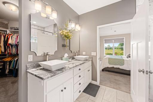Remodeled primary bathroom with granite countertops, new mirrors, lighting and flooring