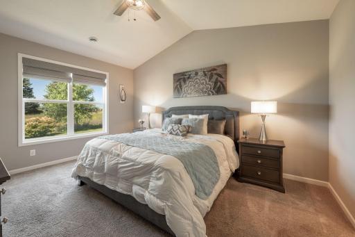 Primary bedroom with backyard views and vaulted ceilings