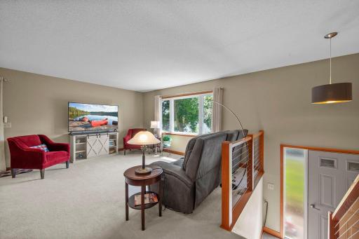First look into your living room with neutral carpet and newer windows.