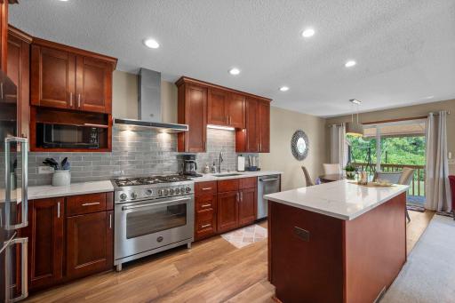 The remodeled kitchen features tons of cherry cabinetry, quartz countertops and pretty backsplash.