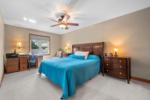 The primary bedroom is big! It has newer windows and neutral carpet and a ceiling fan.