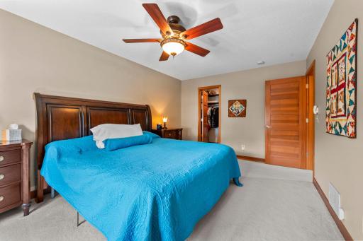Primary bedroom with view into large, walk-in closet.