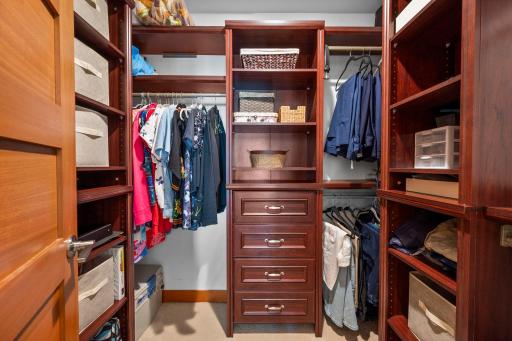 Primary bedroom walk-in closet has custom cherry closet organizers. Wow!