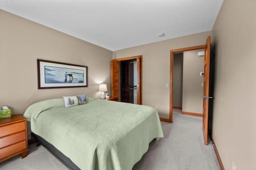 2nd bedroom with view into closet with custom shelving.
