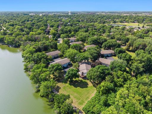 Drone view of open space (lawn) between the home and the lake