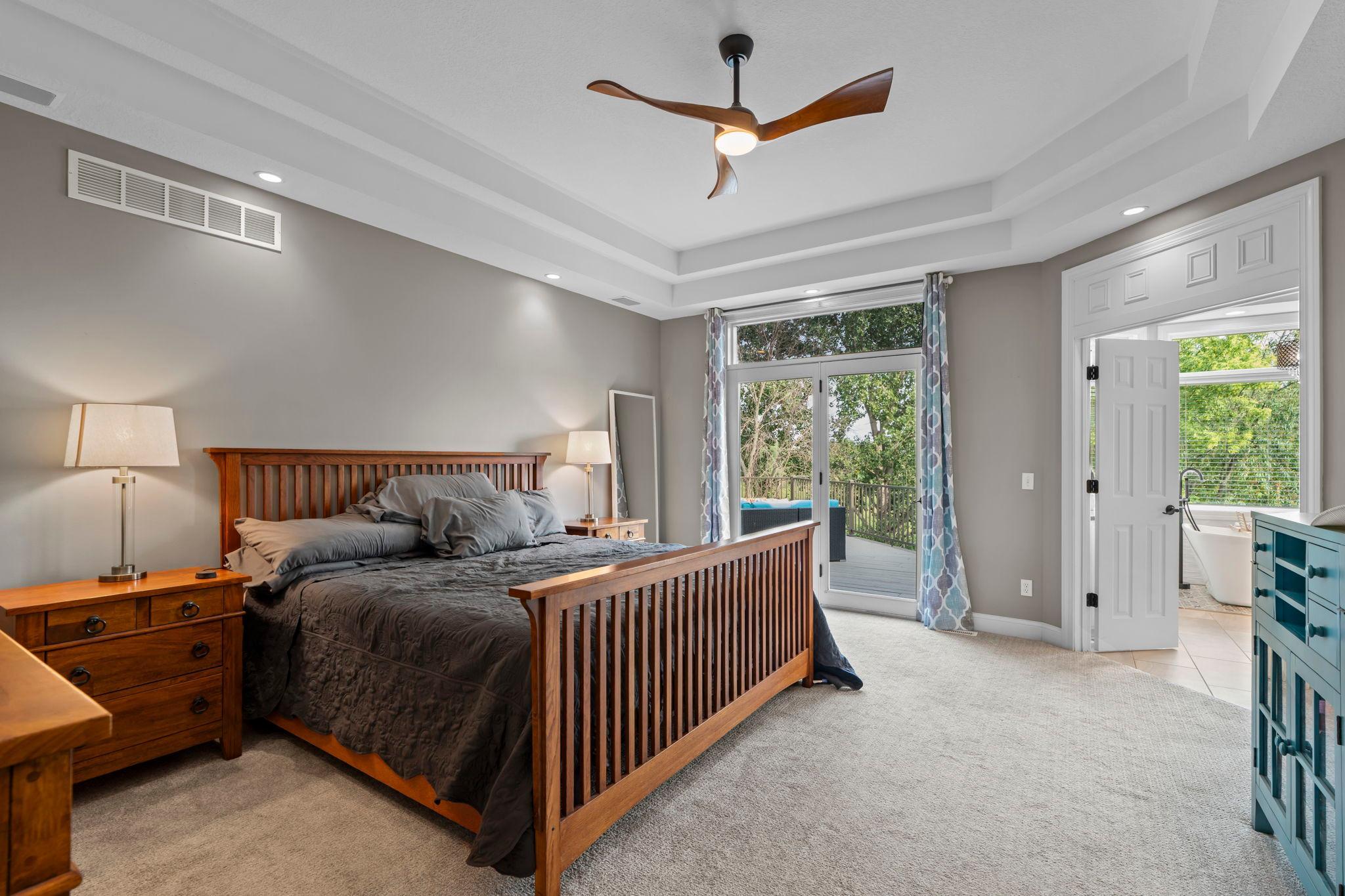 Primary bedroom overlooking the backyard with direct access to the deck