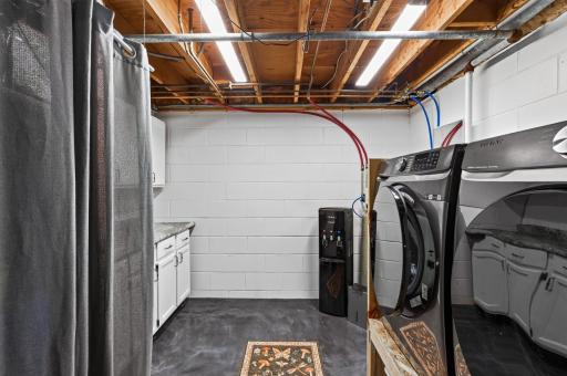 Cozy and inviting laundry room with updated washer and dryer.