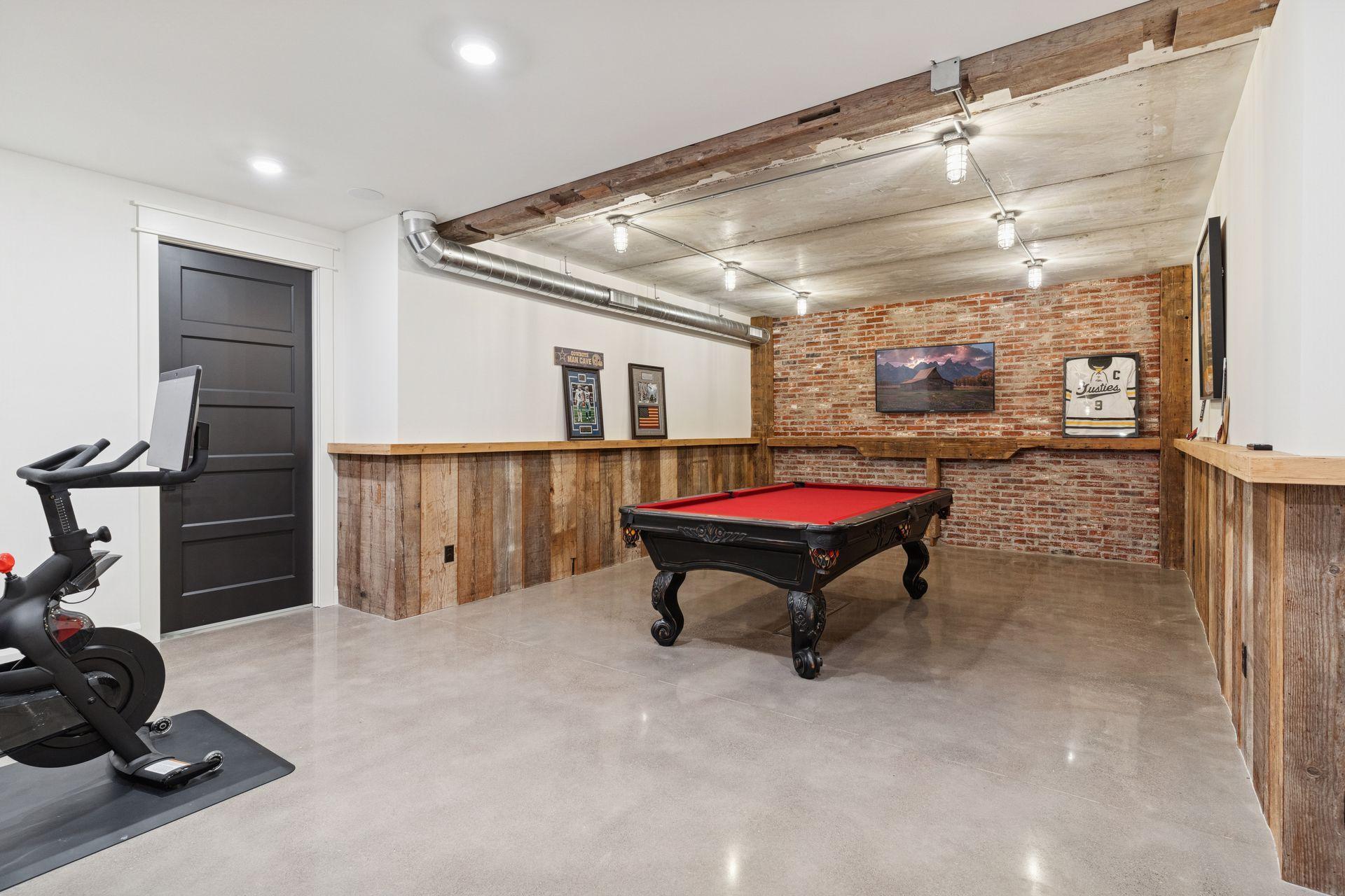 Game Room with concrete flooring, reclaimed wood and floor drain for easy cleanup.