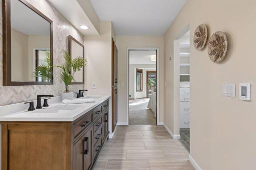 Updated spa-like primary bath suite with heated floors and plenty of storage (walk-in closet as shown to the right)