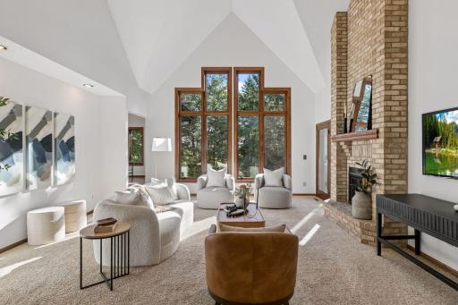 Light and bright great room/living room with a cozy gas fireplace (kitchen to the left and the outdoor porch to the right with the side door)