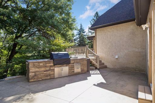 Outdoor kitchen overlooking the firepit to the left and back yard