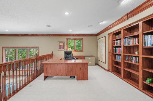 A spacious upper-level loft offers an ideal second office, study or homework area with custom built-in bookcases and abundant natural light. The open railing overlooks the great room below, keeping the space connected while still feeling private.