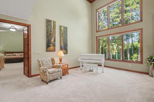 A serene sitting area beside the great room offers a peaceful spot to relax, read or enjoy music while taking in the private, tree-lined views. Two-story windows fill the space with natural light and create a beautiful connection to the outdoors.