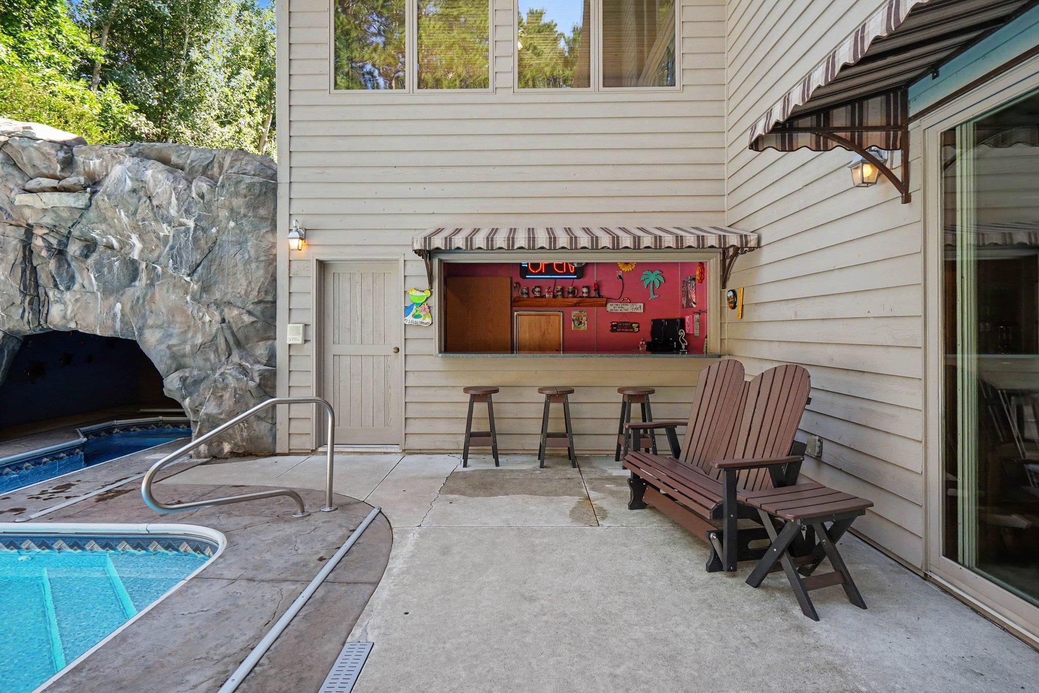 A charming poolside refreshment bar creates the perfect spot for serving snacks, drinks and summertime favorites without leaving the fun. Just steps from the pool and grotto, this inviting gathering space makes outdoor entertaining effortless.