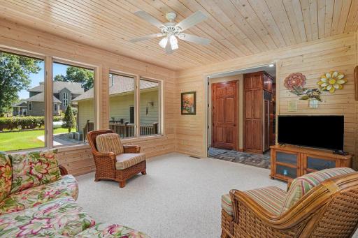 A second view of the four-season porch highlights its generous size, abundant windows and easy flow from the main living areas. Peaceful views of the yard, deck and pool make this a favorite spot to relax, visit or unwind year-round.