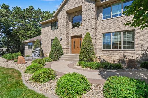 A grand front entry framed by beautiful stonework and professionally landscaped grounds creates an impressive welcome. The curved walkway, mature plantings and striking architectural details add to the home’s exceptional curb appeal.