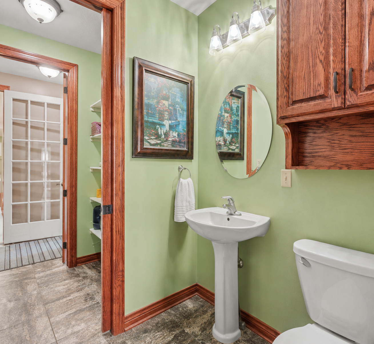 A convenient main-level walk-through bathroom provides easy access from multiple areas of the home, making it practical for both everyday living and guests. Warm wood accents, tile flooring and thoughtful storage add function and character.