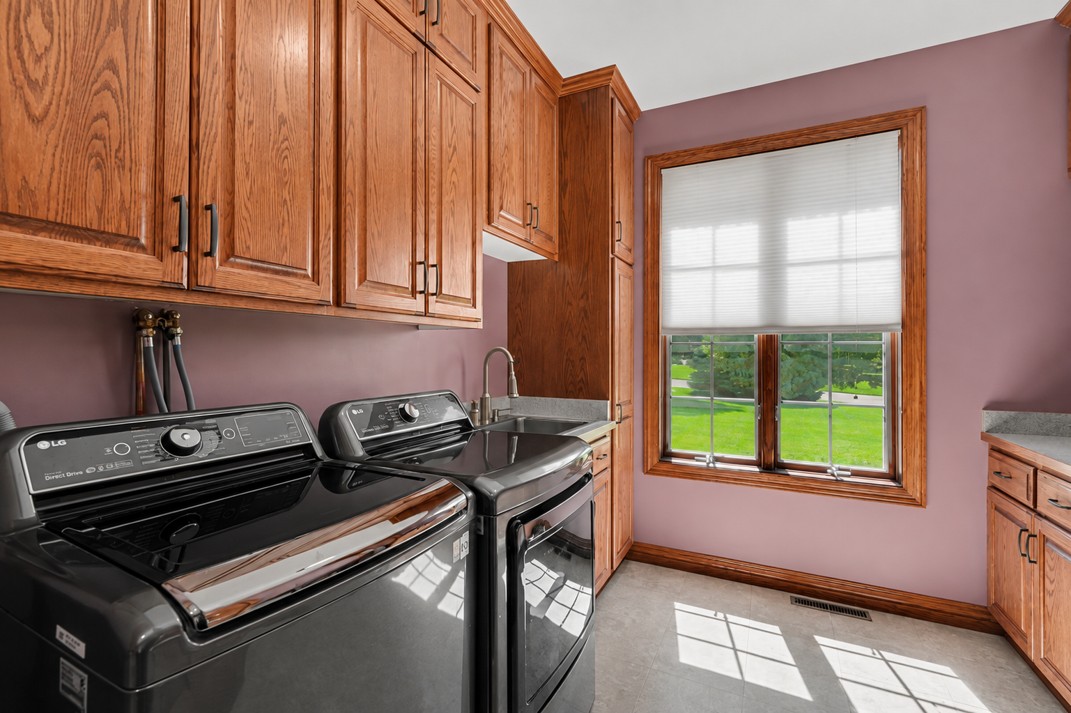 The main-level laundry room offers full-size appliances, abundant cabinetry and generous counter space for everyday organization. A dumbwaiter (currently non-working) adds a distinctive architectural feature to the home’s unique character.