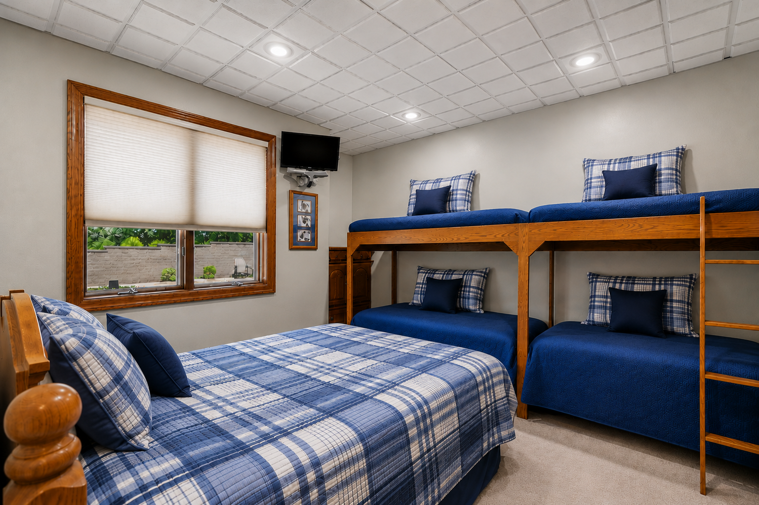 A spacious lower-level bunk room offers flexible sleeping accommodations for family and guests, with room for multiple beds without feeling crowded. A large window brings in natural light, making this a comfortable and practical retreat for overnight