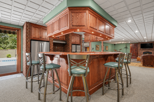 A full lower-level wet bar creates a fantastic gathering space with generous seating, rich cabinetry and room to serve family and friends with ease. Perfect for game days, parties or casual entertaining, it adds another fun and functional dimension t