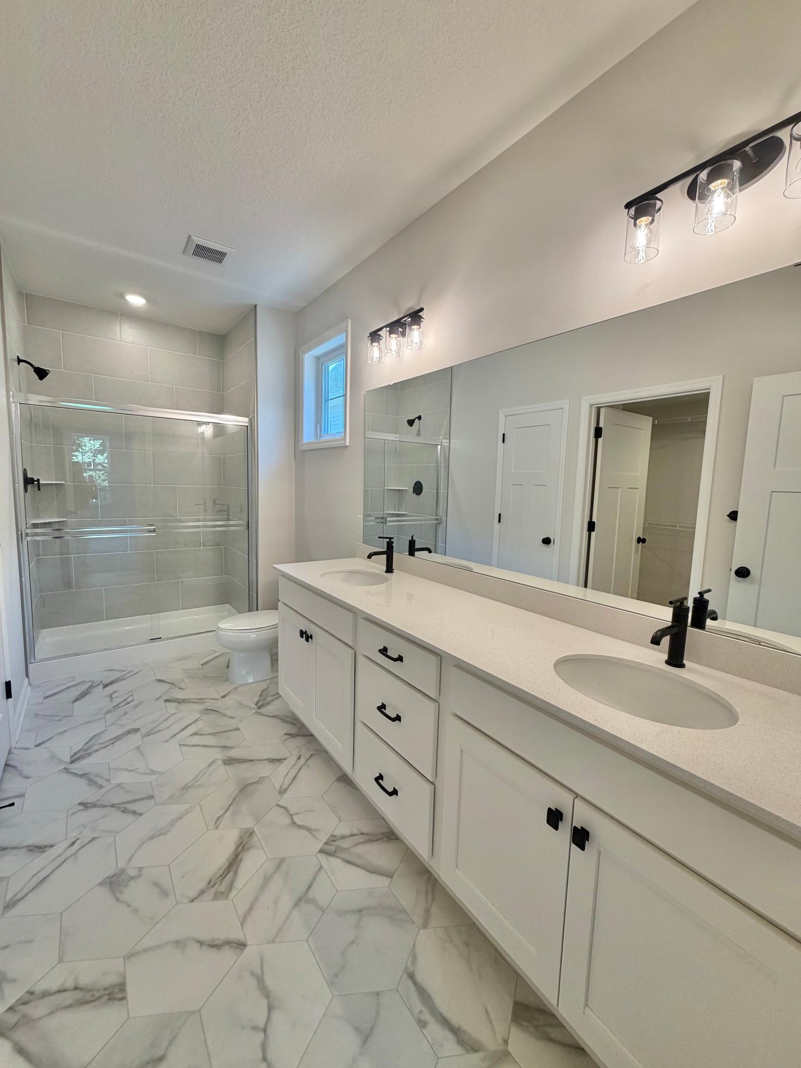 Actual home - owner's bath is a neutral palette with gorgeous tiled shower!