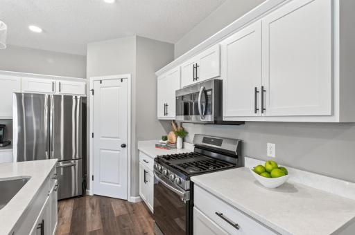 Outfitted with sleek, matching stainless steel appliances, this kitchen delivers both functional precision and a clean, contemporary feel.