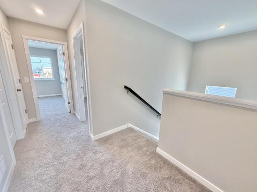 PHOTO OF A DIFFERENT HOME WITH SIMILAR PLAN AND FINISHES. Upper hallway view.