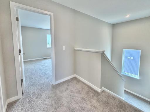 PHOTO OF A DIFFERENT HOME WITH SIMILAR PLAN AND FINISHES. Upper level hallway view.