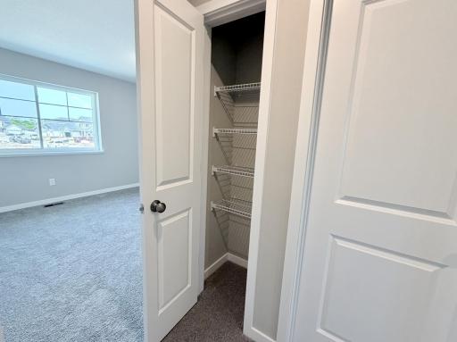 PHOTO OF A DIFFERENT HOME WITH SIMILAR PLAN AND FINISHES. Upper hallway linen closet.