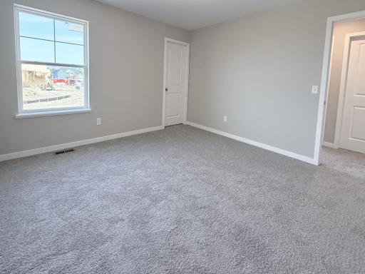 PHOTO OF A DIFFERENT HOME WITH SIMILAR PLAN AND FINISHES. Bedroom 2 features a walk-in closet.