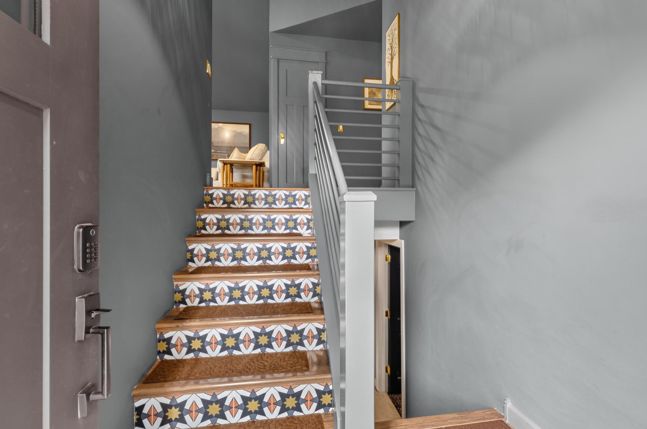 Foyer features built-in shoe shelf and modern railing