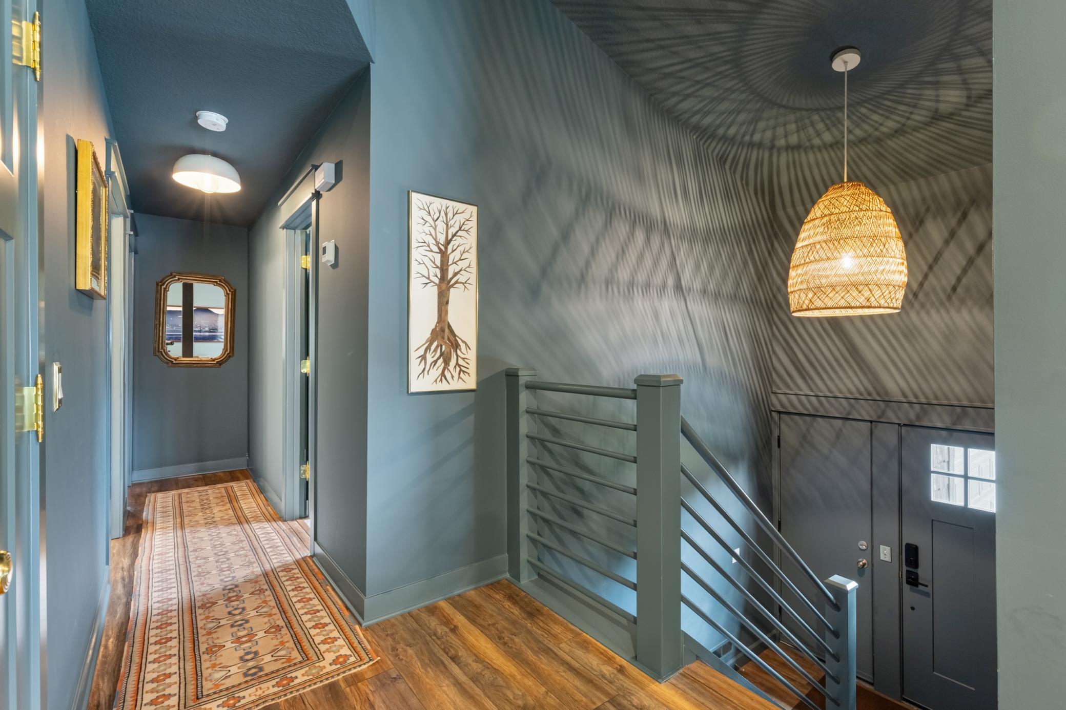 The home features enameled woodwork and interior doors with classic brass hardware. Modern light fixtures highlight home's industrial meets whimsy style