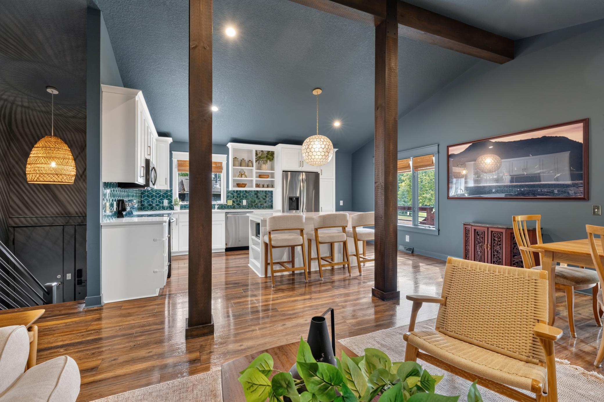 Living Room features vaulted ceilings w/ rustic beam and support posts. Open to both the Kitchen and Dining Room
