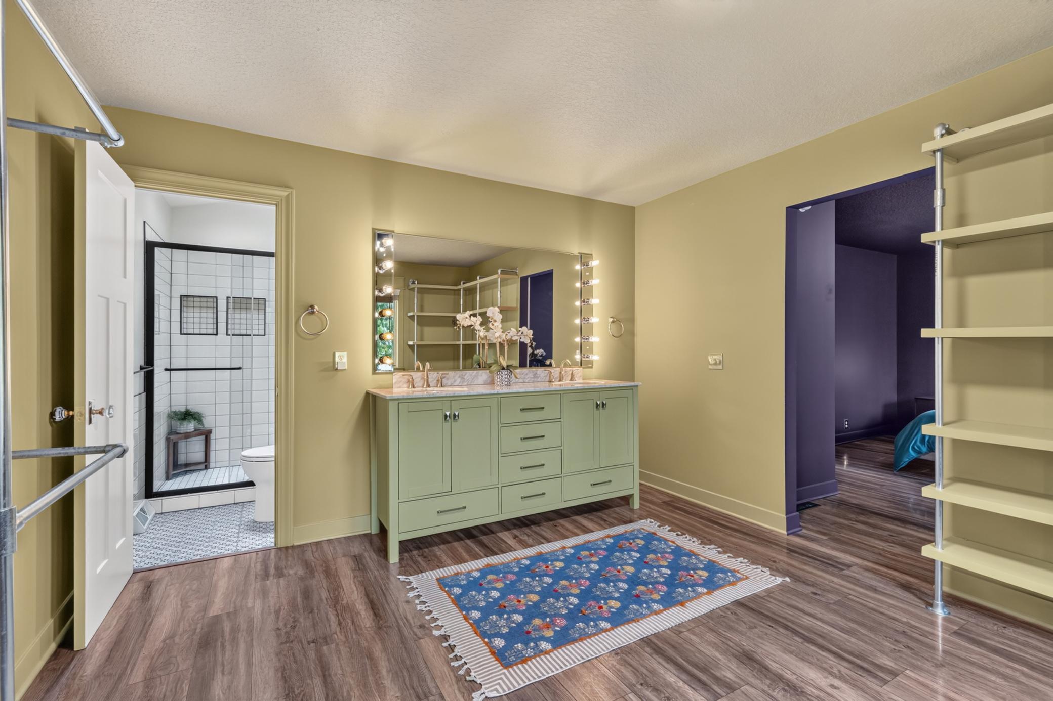 Oversized walk-in Master closet features custom shelving system, enameled vanity cabinet with quartz top and dual sinks