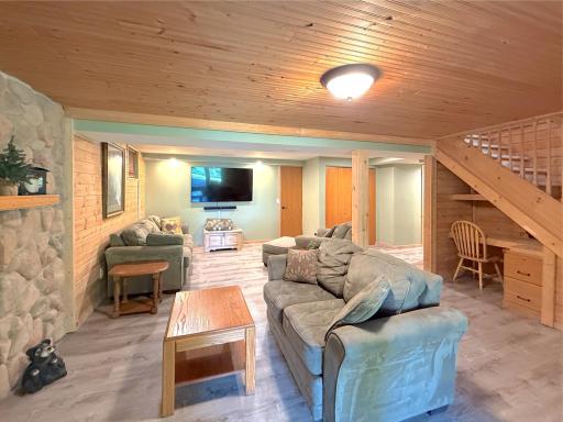 Comfort meets functionality in the inviting lower-level family room, complete with a beautiful stone gas fireplace, built-in desk, and plenty of space to relax or entertain.