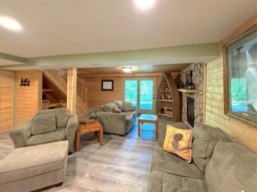Gather around the stone gas fireplace before stepping through the walkout to the covered lakeside patio, ideal for enjoying the peaceful surroundings in any season.