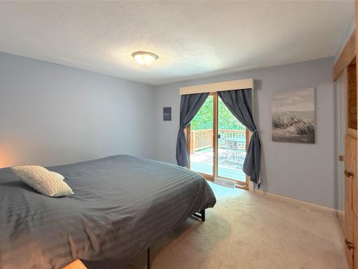 Wake up to peaceful lake views in the spacious primary bedroom, complete with sliding glass doors opening directly to the lakeside deck, enjoy mornings on the lake.