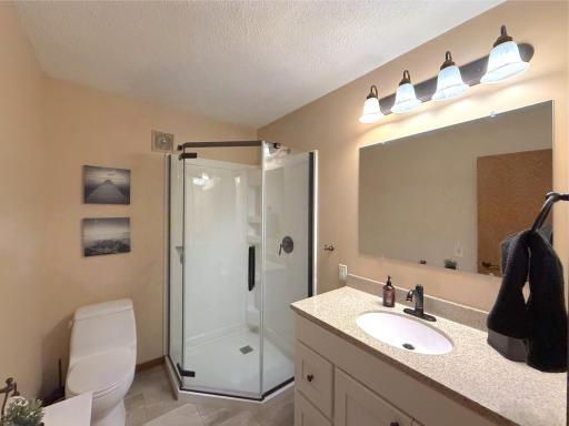 This beautifully updated three-quarter bathroom offers a sleek walk-in shower and stylish finishes for everyday comfort just down the hall from both upper level bedrooms.