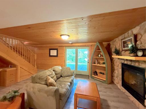 Gather around the floor-to-ceiling stone gas fireplace in this warm and inviting lower leve family room, where rustic wood finishes create the perfect Northwoods retreat.