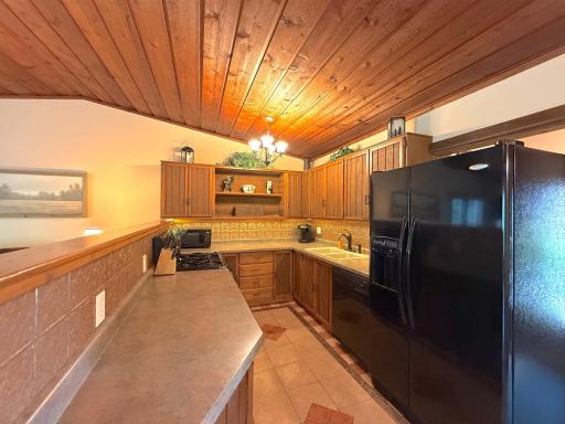 The functional kitchen offers abundant cabinetry, generous counter space, and warm wood finishes that complement the home's rustic charm.
