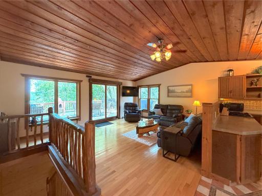 The vaulted tongue-and-groove wood ceiling and open layout create a warm, inviting gathering space with timeless log home character.