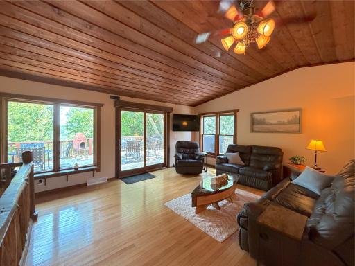 A wall of lakeside windows and sliding glass doors fills the living room with natural light while providing easy access to the expansive deck.