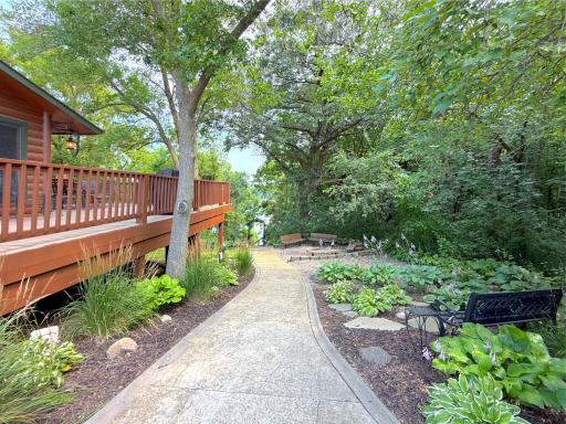 Winding concrete walkways lead through beautifully landscaped perennial gardens to the steps leading to the lakeshore, creating a peaceful, park-like setting.