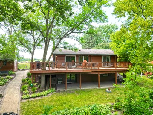 A sprawling lakeside deck spans the length of the home, creating the perfect space for relaxing, dining, and entertaining while overlooking the beautifully landscaped yard.