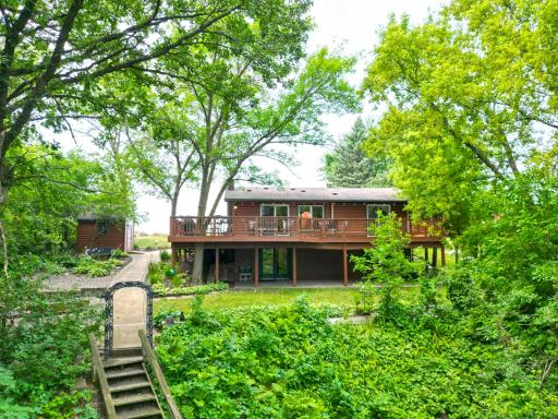 Mature trees and lush landscaping surround this inviting Ramsey Lake log home. Relax on the spacious lakeside deck or covered patio while enjoying peaceful views.