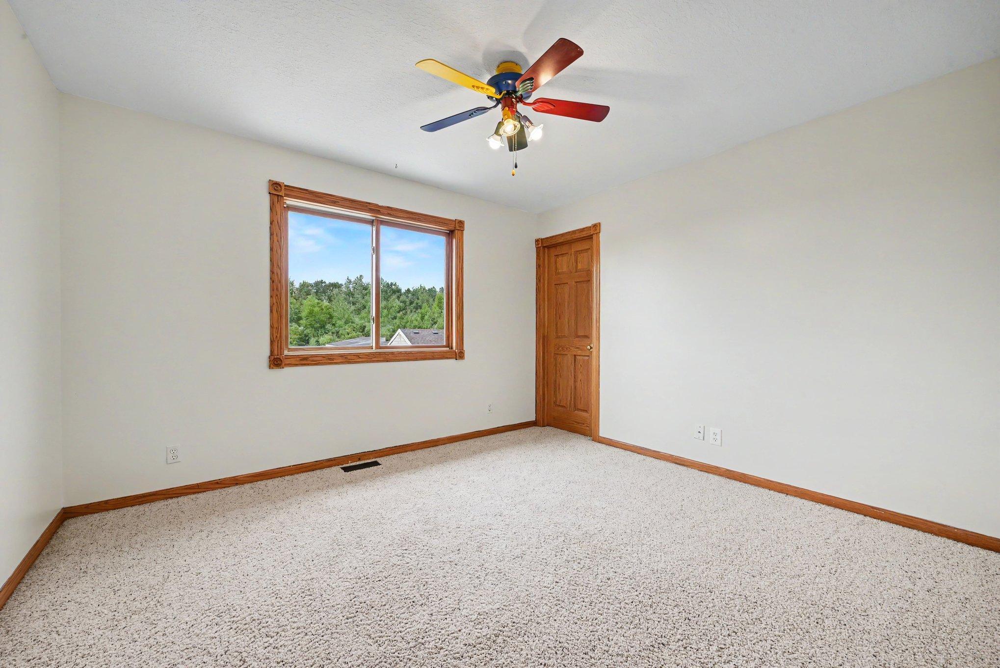 Main-level bedroom #1 with natural light and views of the surrounding property.