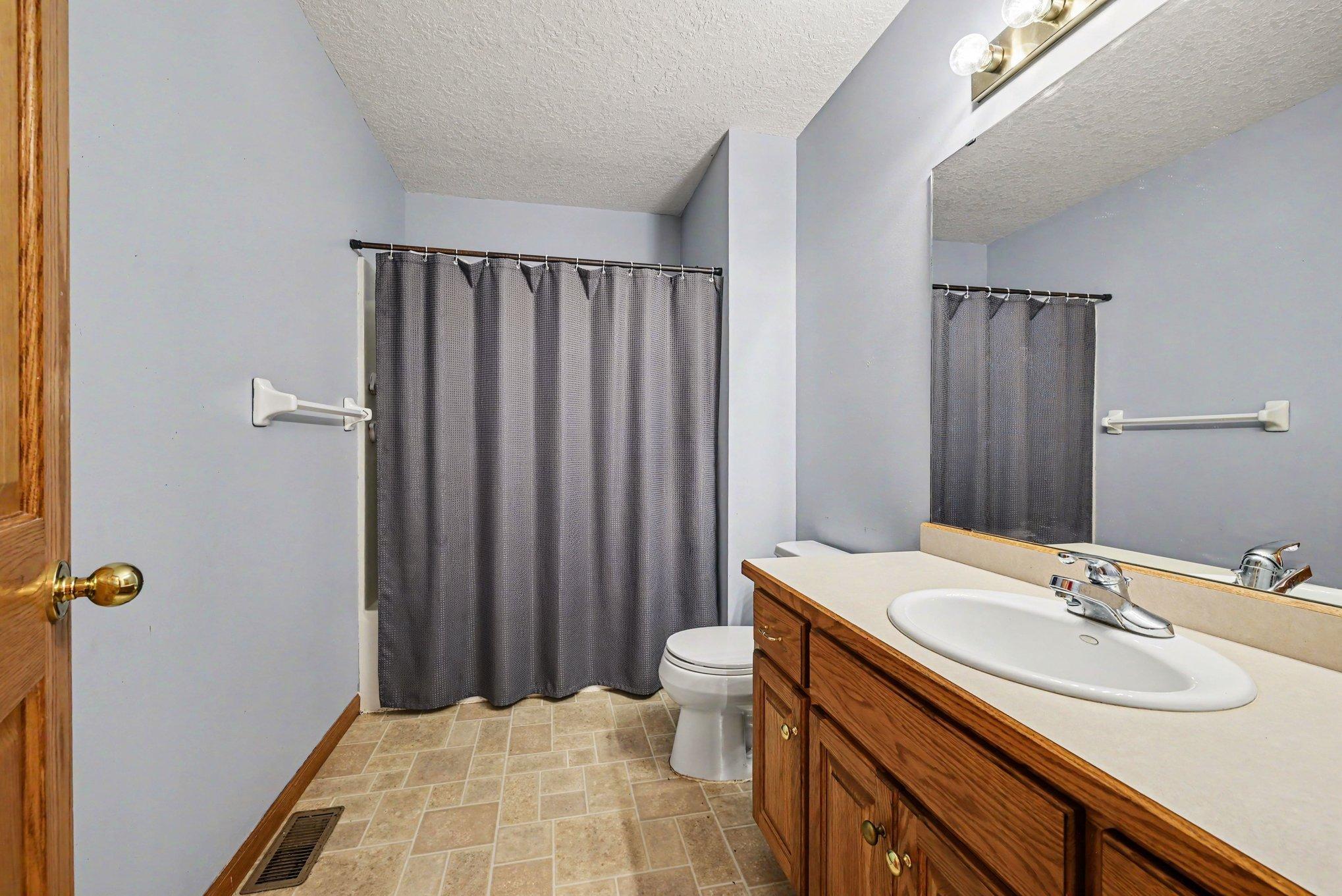Main-level full bathroom with vanity and tub/shower combination.