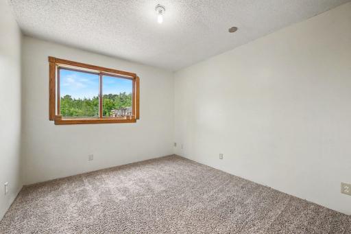 Lower-level bedroom #4 with natural light and views of the property.