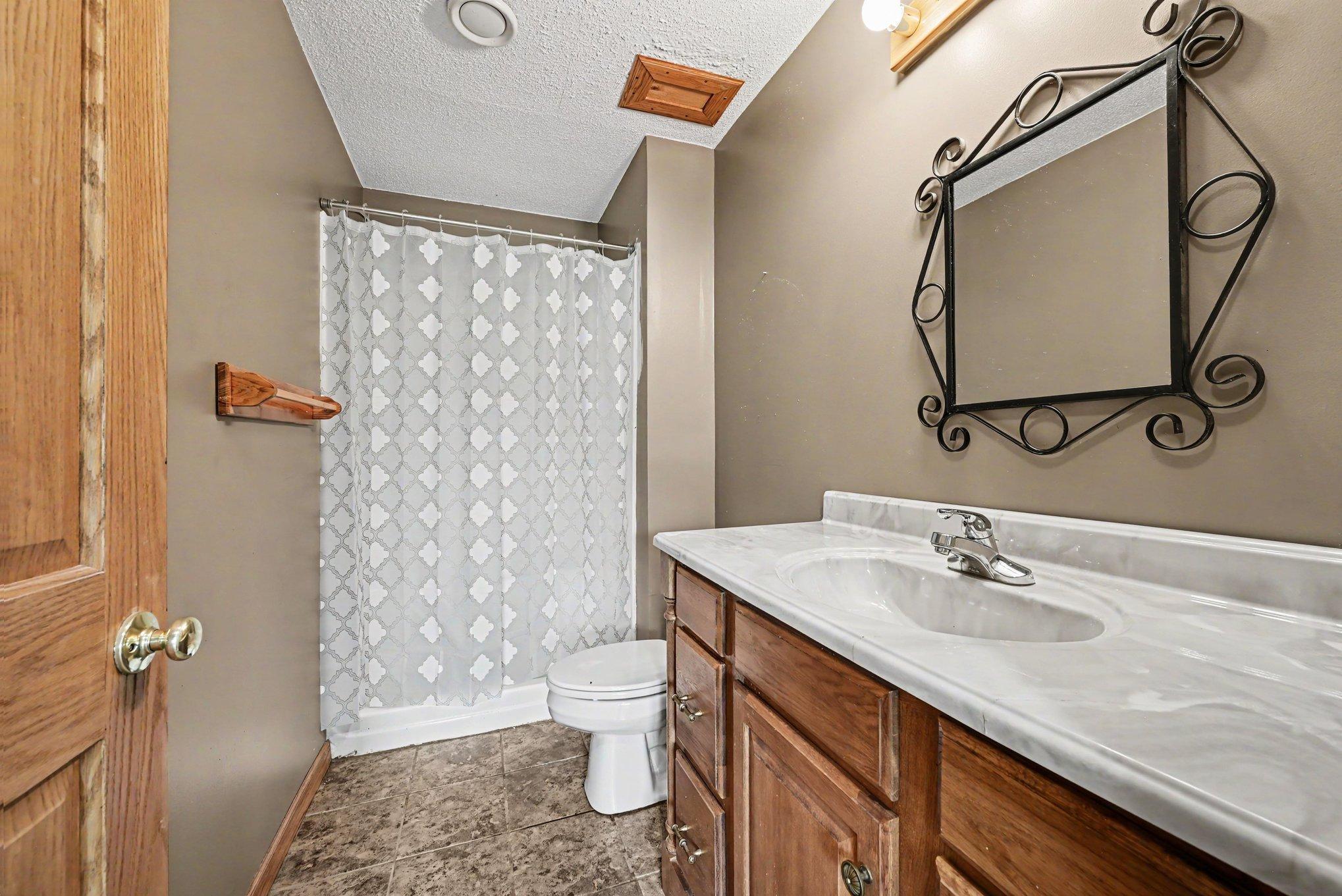 Lower-level 3/4 bath with vanity and walk-in shower.