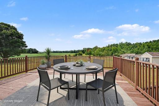 Spacious deck offers plenty of room for outdoor dining, entertaining and enjoying the views. Virtually staged.